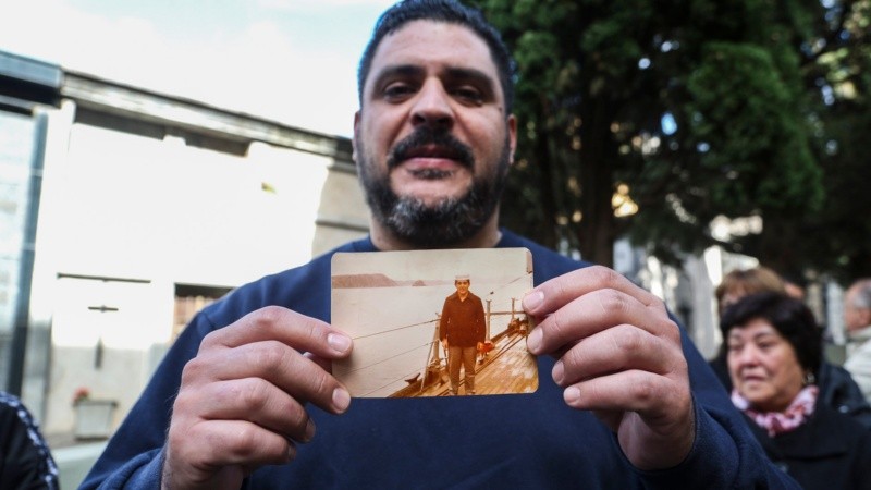 Santiago, hijo de Felipe Gallo, muestra una foto de su padre que le fue regalada por uno de los presentes.