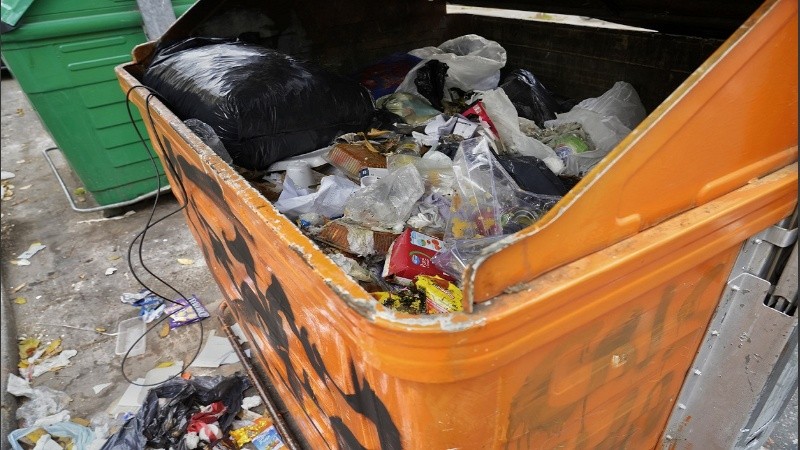 Un container de residuos de separación en Viamonte y Moreno, casi rebalsado y con basura alrededor.