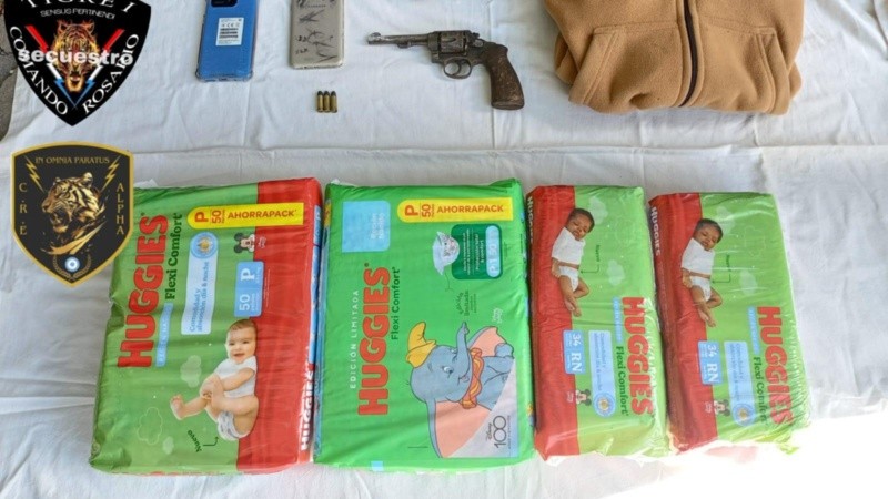 Los pañales robados y el arma de fuego que habría sido utilizada por los delincuentes.