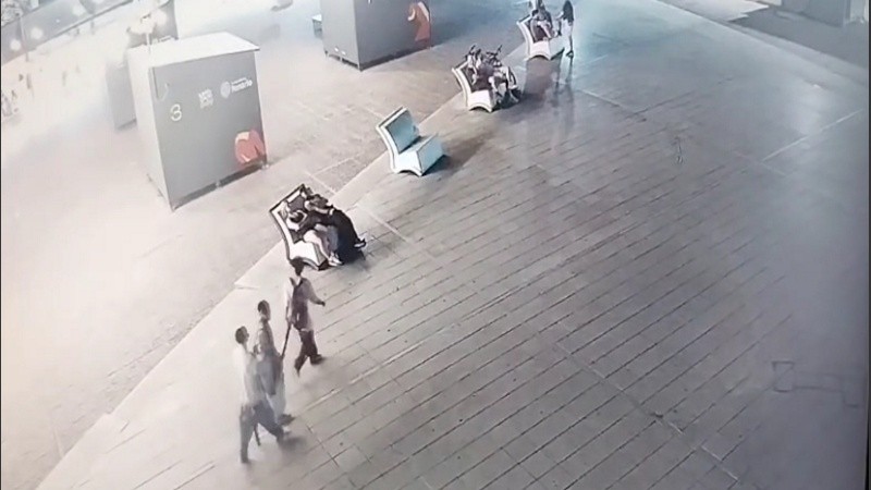 Los tres chicos llevan el cartel robado a cuestas.