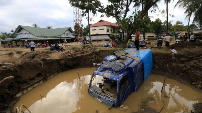 Un camión quedó sepultado en el lodo y las aguas de una aldea afectada por las inundaciones en la zona de Meureudu, Pidie Jaya, Aceh, Indonesia.