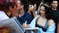Rosalía en su última visita al país, firma autógrafos con una bandera argentina.