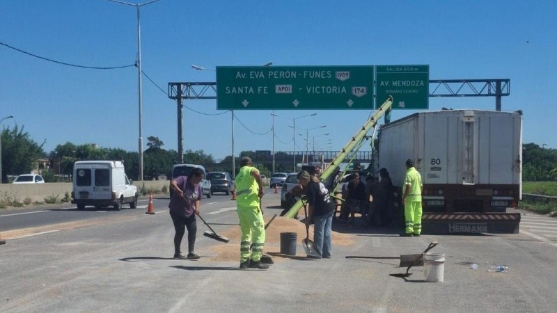 Personal de Corredores Viales trabajando para levantar el cereal derramado.