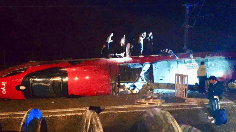 La locomotora y varios vagones tumbados tras el siniestro.