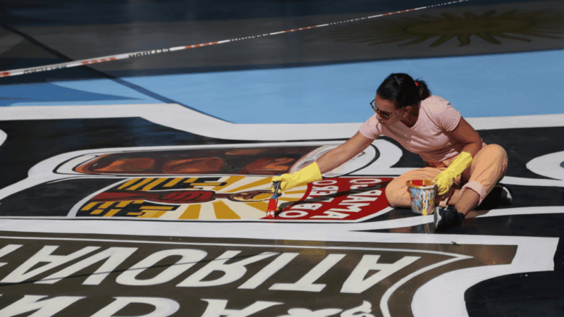 Los artistas trabajan sobre el suelo en el laqueado del mural Río Arriba. (Foto: Alan Monzón / Rosario3)&nbsp;