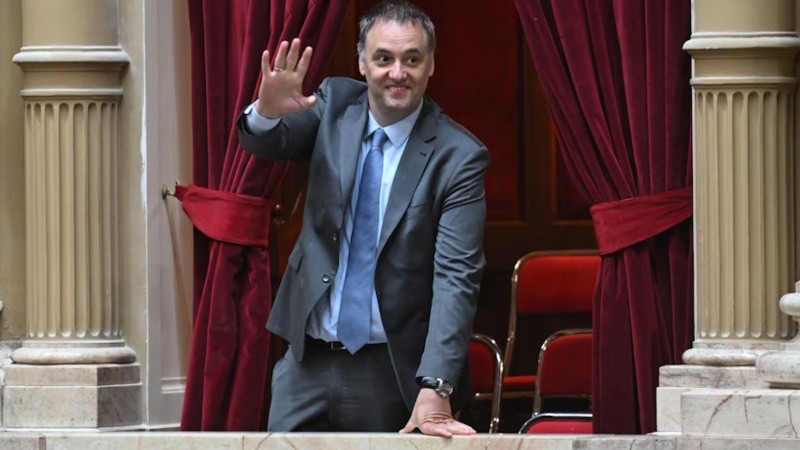 Manuel Adorni saluda desde un balcón del recinto parlamentario.