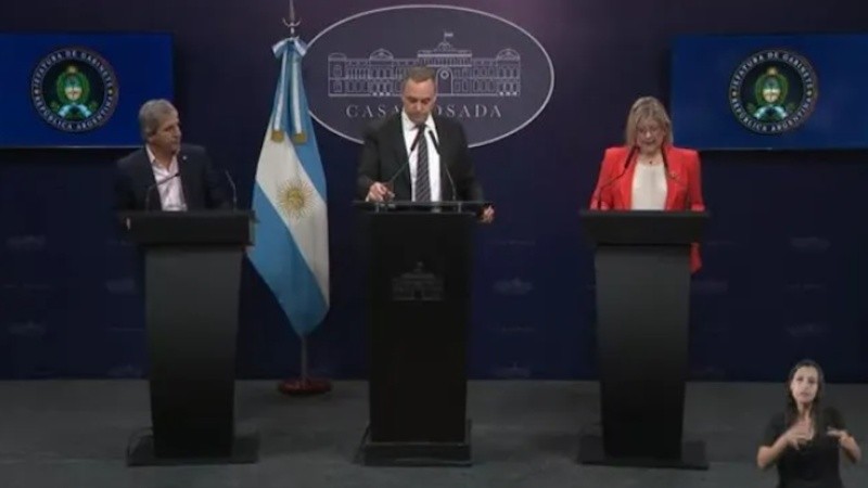 Luis Caputo, Manuel Adorni y Alejandra Monteoliva durante la conferencia.
