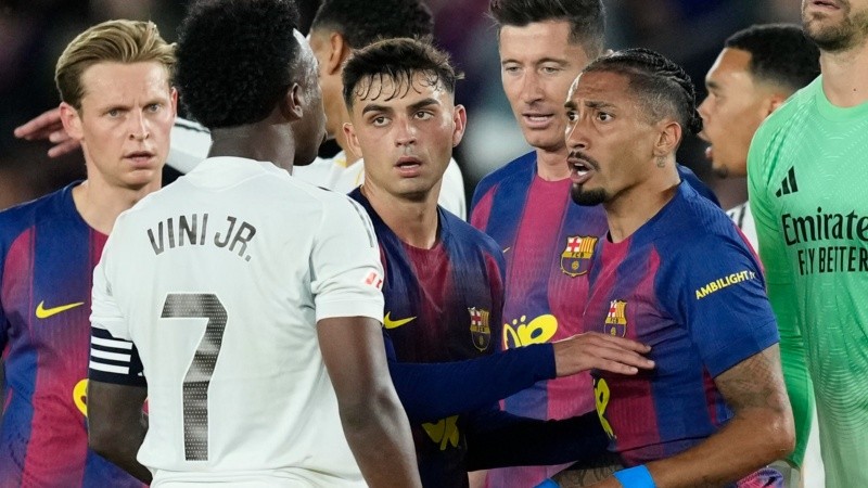 El delantero brasileño del Barcelona Raphinha discute con su compatriota del Real Madrid Vinicius Junior. (EFE)