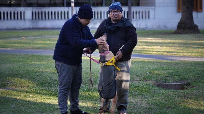 El hijo y el padre de Adrián jugando con la mascota de la familia.