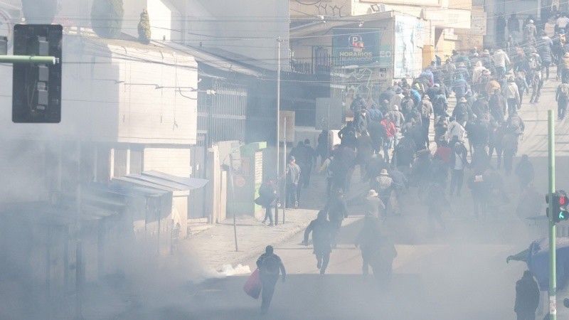 Manifestantes corren durante protestas de este lunes en La Paz. (EFE)