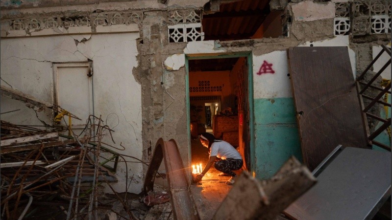Una persona enciende velas durante un homenaje a las victimas por los terremotos del pasado 24 de junio, este viernes en Catia La Mar.