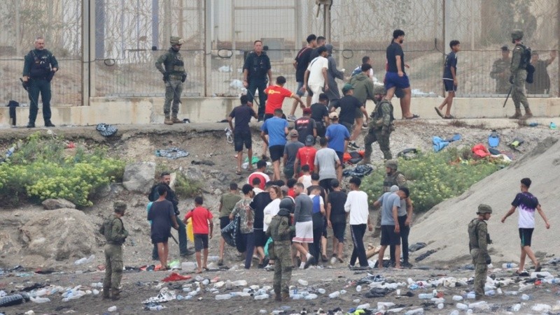  Grupos de inmigrantes empiezan a volver a su país por la frontera del Tarajal en Ceuta este viernes, donde se registraron violentos enfrentamientos en los perímetros fronterizos durante su intento de acceder desde Marruecos hacia Ceuta y Melilla. (EFE/ Reduan Dris)