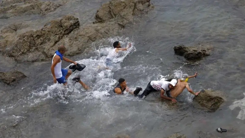Fuerzas de seguridad marroquíes se enfrentan a migrantes que intentan cruzar al enclave español de Ceuta por todas las rutas posibles para ingresar a Europa.&nbsp;