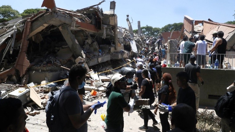 Bomberos y civiles buscan entre los escombros de edificaciones colapsadas en Cali. (EFE)