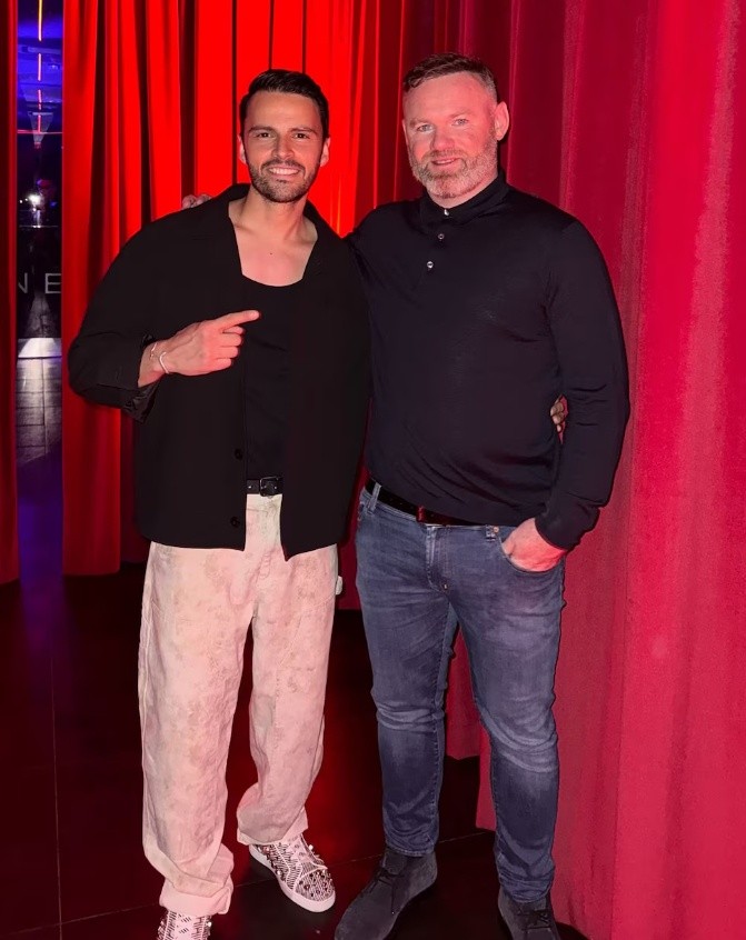 &nbsp;Wayne Rooney posa con una figura destacada de la empresa del escándalo por drogas y servicios sexuales en Europa, en un evento en el interior de un local con cortinas rojas. (Instagram).